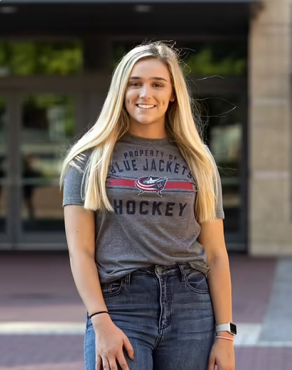 Woman smiling while wearing Columbus Blue Jacket gear