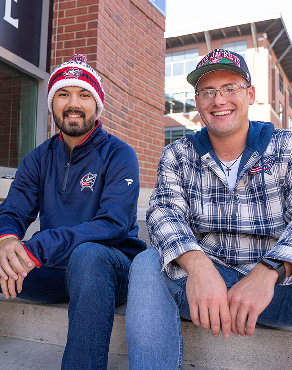 Men wearing Columbus Blue Jacket hat and other gear