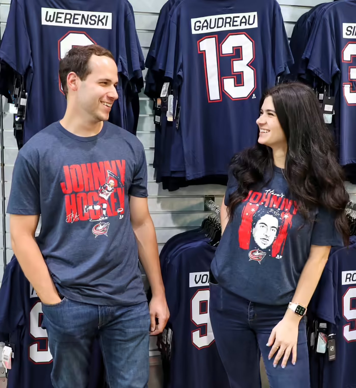 Two friends wearing team gear at Columbus Blue Jacket store